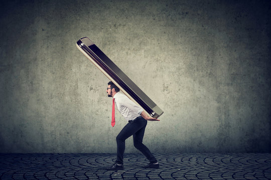 Young Business Man Struggling To Carry Huge Smartphone