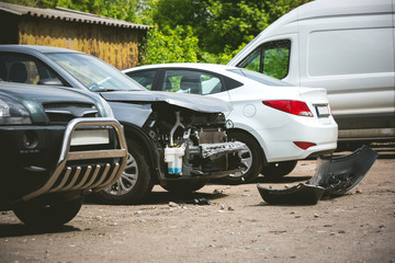 Broken and crashed modern cars after an accident on street, damaged automobile after collision at...