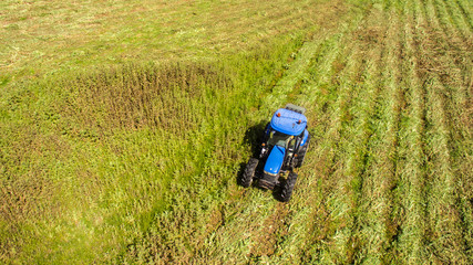 bird eye of tractor mower in operation that cuts the grass in the field of agriculture