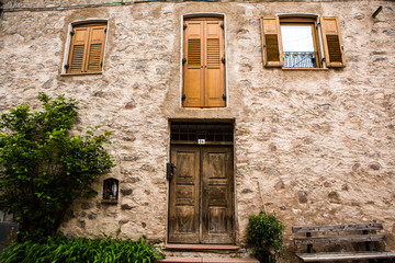 Fototapeta na wymiar Facade of the old European house. Facade of old houses and stone staircase in Italy. Medieval house and door.