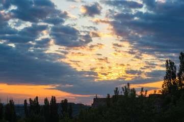 Landscape with dramatic light - beautiful golden sunset with saturated sky and clouds.