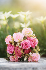 Pink Roses bouquet on concrete floor in the garden with sunlight and green natural background. Valentine Day for love and celebration Concept.
