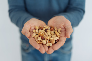 Man holding a handful of healthy mixed nuts