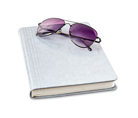 Grey leather notebook diary and sunglasses.