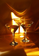 Deux verres à pied contenant du vin blanc dans une lumière dorée