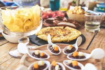 Close up view of many foods on a wooden table. Viande multicolor ready for a party. Apetizing colorful buffet. Summer aperitif, joy and family holidays, dinner on the terrace. Light lunch to share.