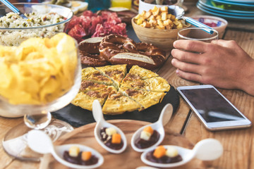 Close up view of many foods on a wooden table. Viande multicolor ready for a party. Apetizing colorful buffet. Summer aperitif, joy and family holidays, dinner on the terrace. Light lunch to share.