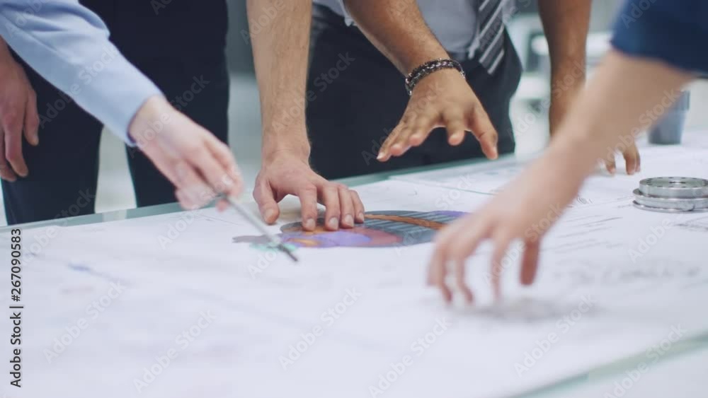 Aufkleber Industrial Engineering Facility: Close-up on Hands of Group of Engineers, Technicians and Specialists on a Meeting, Tracing Lines and Analysing Engine Design Technical Drafts Laying on the Table