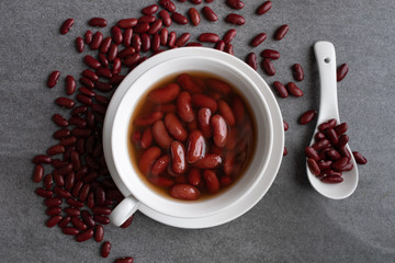 Sweet boiled red beans in white cup on concrete table.