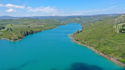 Naklejka na ściany i meble Aerial drone photo of famous lake and dam of Marathon or Marathonas with beautiful clouds and blue sky, North Attica, Greece