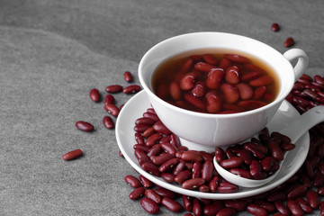 Sweet boiled red beans in white cup on concrete table.