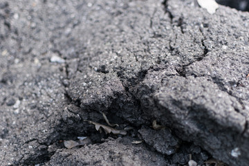 Old asphalt with cracks. The texture of the damaged pavement.