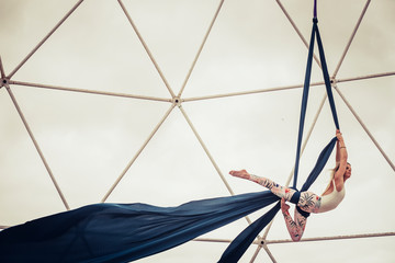 Sport healthy lifestyle people alternative dance in the sky balanced with cords and fabrique - clear white sky in background and steel structure - circus training for fitness babe © simona