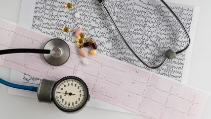 medical stethoscope with tonometer and ecg on a light background. top view
