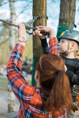 The little boy is wearing climbing gear.