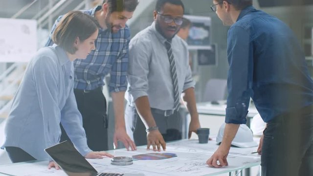 In the Industrial Engineering Facility: Diverse Group of Engineers, Technicians, and Specialists on a Meeting, Have Discussion, Analyse Engine Design Technical Drafts that are Lying on the Table