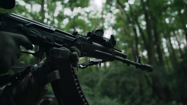 Fully equipped soldier reloads rifle. AK 74.