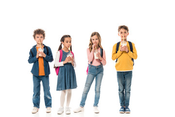 full length view of schoolchildren drinking milkshakes isolated on white