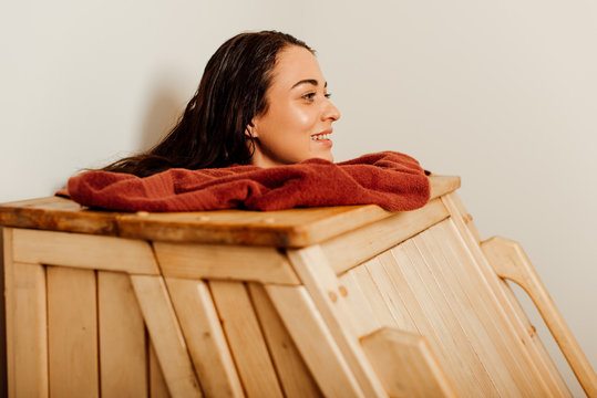 smiling woman taking steam bath in spa center