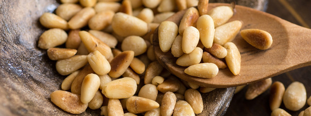 Pine Nuts on Dark Wooden Table. Toasted Organic Healthy Food.