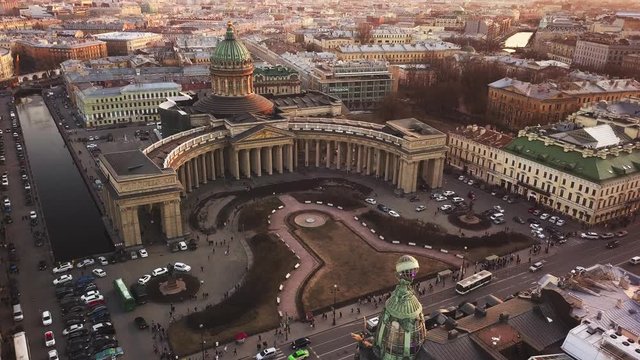 Aerial spring sunset view of Saint Petersburg Nevsky prospect Kazan cathedral Kazanskiy Kafedralniy Sobor Singer House of the Book tower Griboyedov Canal church roofs road cars rooftops famous place o