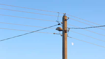 Electrical wires on elecrticity pylon close up on blue sky background