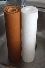 Old and new water filters in kitchen sink - drinkable water cleansing