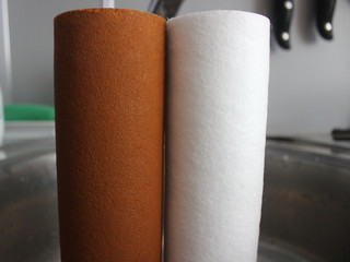 Two water filter cartridges close up - old and new in kitchen sink, drinkable water cleansing