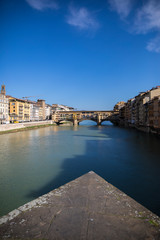 Sunny view on the Arno River and Ponte Vecchio in Florence, Italy