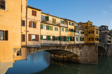 Fototapeta na wymiar Sunny view on the Arno River and Ponte Vecchio in Florence, Italy