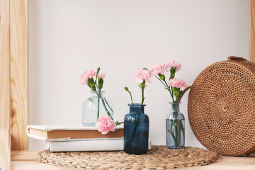 beautiful glass vases, wicker bag on a shelf near the wall
