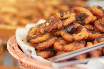 Delicious sweet dessert of Thai Traditional Style Donuts with chocolate on top homemade on rattan basket in wedding ceremony.