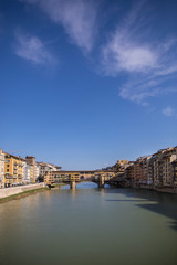 Obraz premium Sunny view on the Arno River and Ponte Vecchio in Florence, Italy