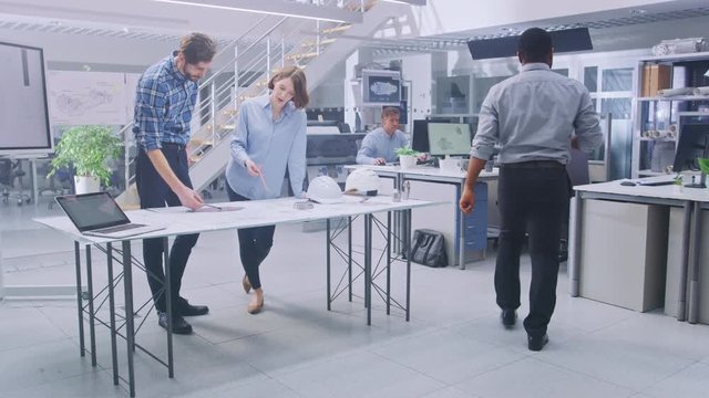 In the Busy Engineering Facility: Diverse Group of Engineers, Technicians, Working on Design for Industrial Engine Prototype. Specialists Talk During Meetings, Work with Drawings, Use Computers