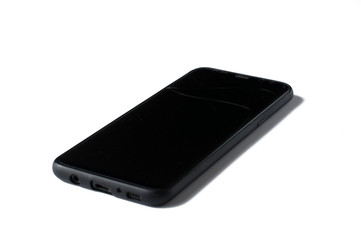 A black phone with a cracked screen isolated on a white background.