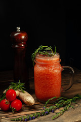 fresh tomato in a glass on a wooden background