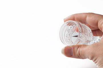 A glass holding a hand isolated on a white background.