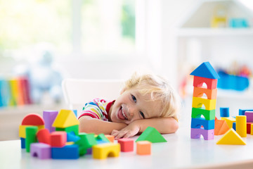 Kids toys. Child building tower of toy blocks.