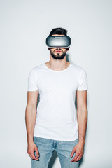 bearded man wearing virtual reality headset while standing on white