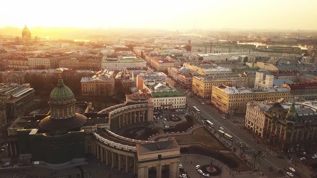 Aerial spring sunset view of Saint Petersburg Nevsky prospect Kazan cathedral Kazanskiy Kafedralniy Sobor Singer House of the Book Neva river roofs road cars rooftops famous place of Russia religion