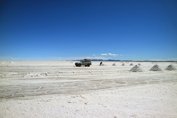 Salt miner extracting salt on Uyuni salt flats or El Salar de Uyuni in Potosi department, Bolivia