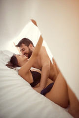 couple sharing intimate moments in bedroom.