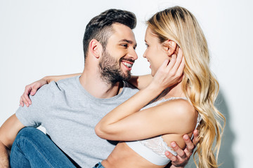 happy bearded man looking at attractive blonde girl on white