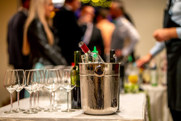 Ice bucket,  wine bottles and glasses on table