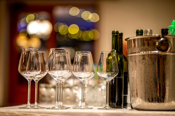 Wine glasses, bottles and ice bucket on table