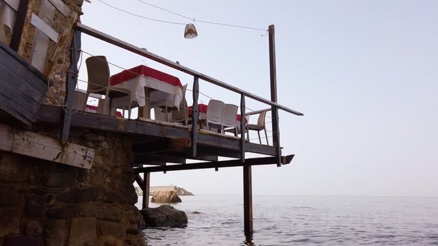 Tavolini di un ristorante su un ponteggio in riva all'acqua.