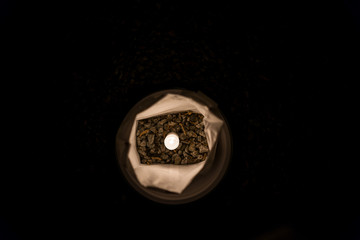 Christmas Eve one, single candle lights flame illuminated in paper bag flat top view looking down at night lining street road by residential neighborhood house decoration during religious holiday