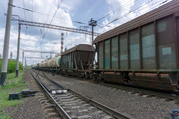 Obraz premium The train passes on a railway through the city, sunny day with blue sky and clouds. Kyiv(Kiev), Ukraine.