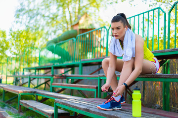 Sporty woman ties her shoes, getting ready for workout