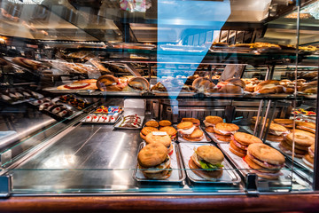 Display of store shop selling Italian panini sandwiches deli and croissants on tray platter glass...